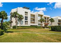 Modern condo building with lush landscaping and ample parking at 50 Coe Rd # 331, Belleair, FL 33756
