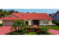 Single-story home with red tile roof, landscaping, and a paved driveway at 4981 61St S Ave, St Petersburg, FL 33715