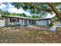 Ranch-style home with stone accents, landscaping, and a spacious yard at 2499 Indigo Dr, Clearwater, FL 33763