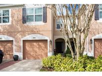 Townhouse exterior featuring a two-car garage and landscaping at 2619 Redford Way, Wesley Chapel, FL 33544
