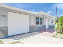 Updated home exterior with gray paint and stone accents at 4969 Lemonwood Loop, Holiday, FL 34690