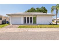 White single story home with attached garage and green door at 5396 Acacia N Trl, Pinellas Park, FL 33782