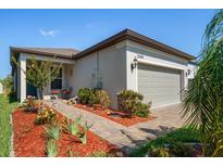 Beautiful home exterior with landscaped yard and attached garage at 20591 Monza Loop, Land O Lakes, FL 34638