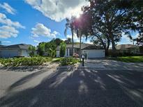 Charming home with a well manicured lawn, a two car garage, and mature trees in a suburban neighborhood at 1638 Polo Club Dr, Tarpon Springs, FL 34689