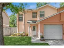 Two-story house with peach-colored siding, attached garage, and well-maintained lawn at 5171 Corvette Dr, Tampa, FL 33624