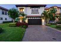 Two-story house with a brick driveway, landscaping, and a two-car garage at 3565 Torino Ln, Palm Harbor, FL 34683