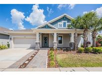 Inviting single-Gathering home featuring a charming front porch, well-maintained lawn, and lush landscaping at 16701 Vibrato Ln, Land O Lakes, FL 34638