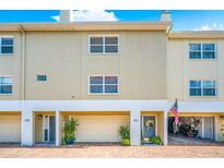 Charming townhome featuring an attached garage, brick paved driveway, and manicured landscaping at 1109 Pinellas Bayway S # 306, Tierra Verde, FL 33715
