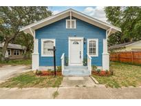 Charming blue house features a well-manicured front yard, white trim and a welcoming front porch at 49 W Boyer St, Tarpon Springs, FL 34689
