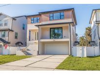 Contemporary two-story home with a large garage, sleek lines, and a well-manicured lawn at 1735 Massachusetts Ne Ave, St Petersburg, FL 33703