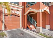Exterior view of a condo building with a garage and stairs at 2746 Via Tivoli # 132B, Clearwater, FL 33764