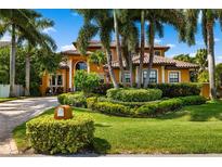 Charming two-story home with a tile roof, lush landscaping, and a circular driveway at 620 Ponce De Leon Dr, Tierra Verde, FL 33715