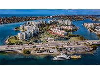 Stunning aerial view of waterfront condos with lush landscaping and a boat dock in a coastal community at 7979 Sailboat Key S Blvd # 506, South Pasadena, FL 33707