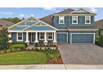 Two-story home with blue exterior and three-car garage at 4219 Woodland Retreat Blvd, Trinity, FL 34655