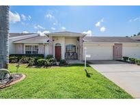 Brick front home with two-car garage and well-manicured lawn at 1044 Blyth Hill Ct, Trinity, FL 34655