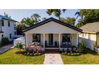 Charming single-story home featuring a well-manicured lawn and inviting front porch with seating area at 316 11Th N Ave, St Petersburg, FL 33701