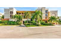 Two-story condo building with lush landscaping and ample parking at 7532 Bayshore Dr # 205, Treasure Island, FL 33706