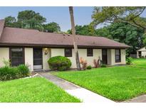Exterior view of condo, showing a well-maintained lawn and building at 1354 Azalea Dr # 1803, Dunedin, FL 34698
