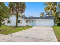 Charming single-story home with a lush lawn, a large driveway, and a welcoming light blue front door at 508 Brooker Rd, Brandon, FL 33511