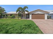 Charming single-story home featuring a well-manicured lawn and a two-car garage at 2049 Massachusetts Ne Ave, St Petersburg, FL 33703