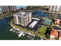 Aerial view of waterfront condo building with tennis court and marina at 1651 Sand Key Estates Ct # 74, Clearwater Beach, FL 33767