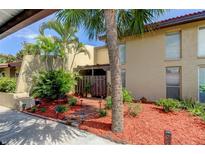Attractive Florida condo with palm trees, brick pathway, and well-manicured landscaping at 7200 Ulmerton Rd # F2, Largo, FL 33771
