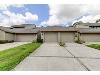 Attached two-car garage with lush green lawn in front at 3050 Landmark Blvd # 1003, Palm Harbor, FL 34684