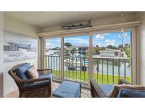 Bright sunroom with wicker furniture and stunning water views at 175 116Th Ave # 102, Treasure Island, FL 33706