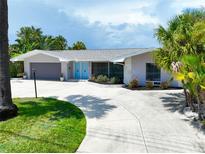 Mid-century modern home with gray exterior and blue doors at 6460 Fairway View S Blvd, St Petersburg, FL 33707