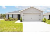 Newly built home with a two-car garage and well-manicured lawn at 102 Eagle Summit Dr, Ruskin, FL 33570