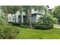 Modern house exterior with lush landscaping and palm trees at 7643 Ginger Lily Ct, Tampa, FL 33619