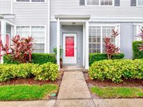 Townhouse with red front door, landscaping, and walkway at 2745 Enterprise E Rd # 24, Clearwater, FL 33759