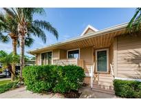 Tan house exterior with lush landscaping and palm trees at 1008 Caravel Ct, Tarpon Springs, FL 34689