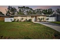 Tan single story home with white fence and landscaping at 831 Searcy Ave, Sarasota, FL 34237