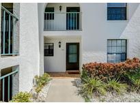 Condo building exterior, unit 115, featuring a walkway and landscaping at 1730 Manasota Beach Rd # 115, Englewood, FL 34223