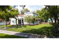 Two-story house with a white stucco exterior, red brick walkway, and a lush lawn at 5501 Bates St, Seminole, FL 33772