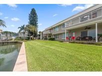 Spacious backyard with lush green grass, overlooking a canal at 400 Larboard Way # 106, Clearwater Beach, FL 33767
