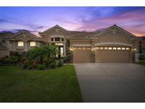 Two-story home with neutral exterior, three-car garage, and landscaping at 11519 Belle Haven Dr, New Port Richey, FL 34654