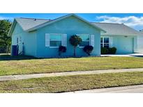 Charming light blue home with well-maintained lawn and landscaping at 6196 Coralberry Ter, Port Charlotte, FL 33981