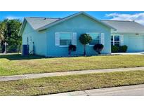 Charming light blue single-story home with a well-manicured lawn at 6196 Coralberry Ter, Port Charlotte, FL 33981