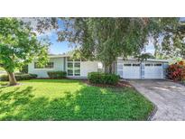 Charming single-story home with a well-manicured lawn and a two-car garage at 161 Overbrook W St, Largo, FL 33770