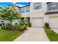 Townhouse exterior with two-car garage and landscaping at 7203 Sweet Alyssum Ct, Tampa, FL 33619