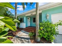 Light teal single-story home with a red brick walkway and lush landscaping at 1549 Linwood Dr, Clearwater, FL 33755