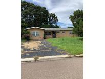 One-story house with overgrown lawn and driveway at 385 Dolphin Se Ave, St Petersburg, FL 33705