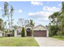 Single-story house with brown garage door and landscaping at 2193 Peake St, North Port, FL 34286