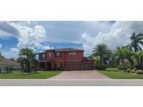 Two-story house exterior with brick paver driveway and lush landscaping at 7607 55Th E St, Ellenton, FL 34222