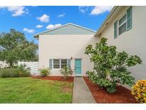 Charming condo building with a teal door and landscaping at 3247 38Th S Way # C, St Petersburg, FL 33711