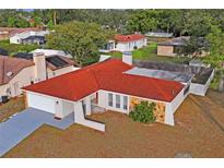 Single story home with red tile roof and large backyard at 2502 Indigo Dr, Dunedin, FL 34698