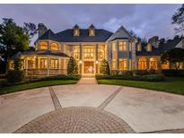 Grand brick house with a circular driveway at dusk at 2901 Leprechaun Ln, Palm Harbor, FL 34683