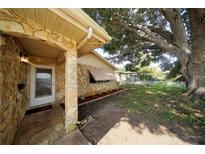 Charming stone front porch with a large oak tree in the yard at 824 62Nd Ne Ave, St Petersburg, FL 33702
